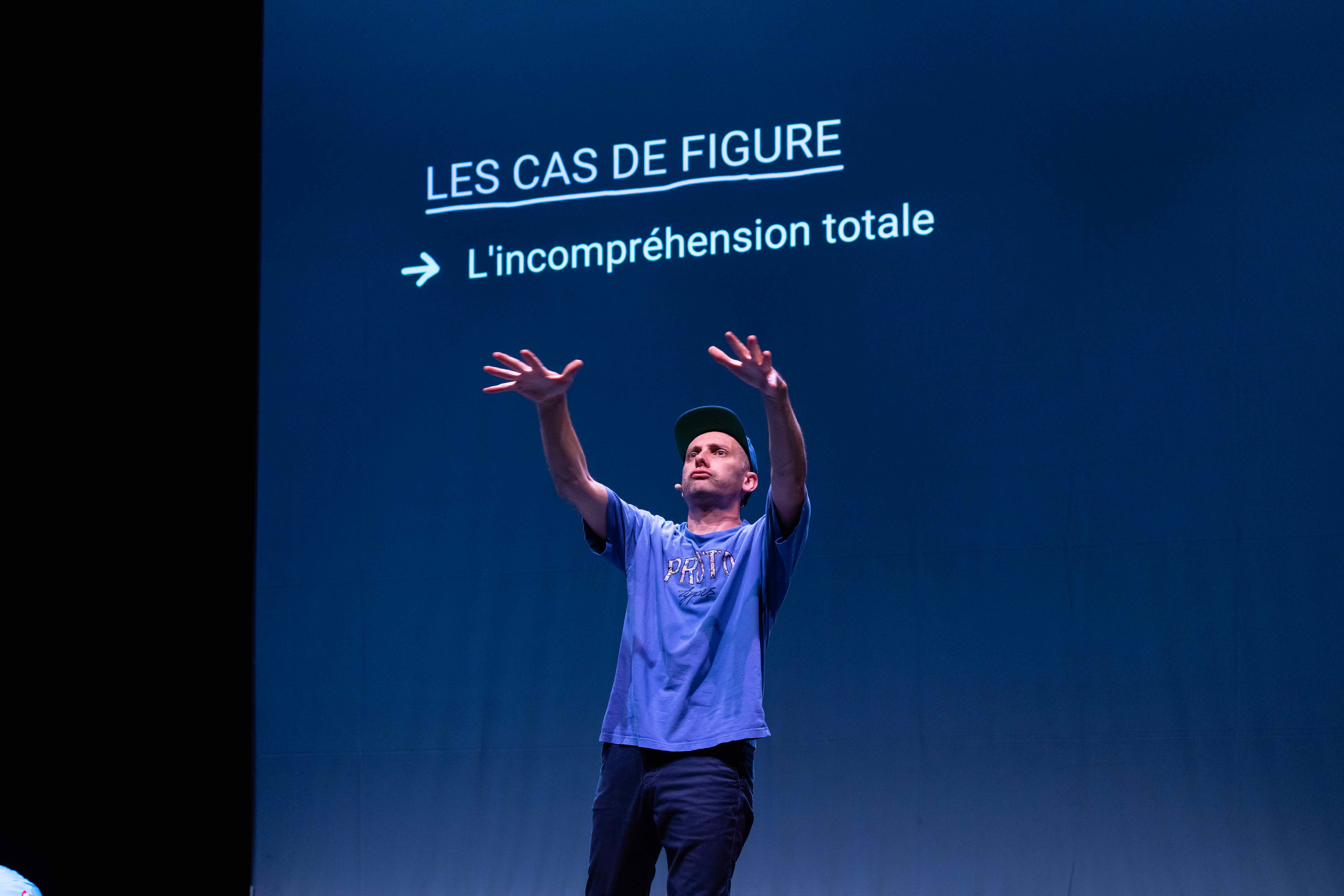 Antoine Defoort, les mains en l'air, semble faire un truc genre 
